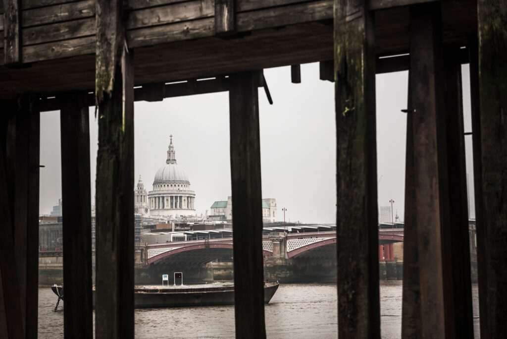 St Paul's Cathedral seen below a pier on the banks of the River Thames, South Bank, London, England